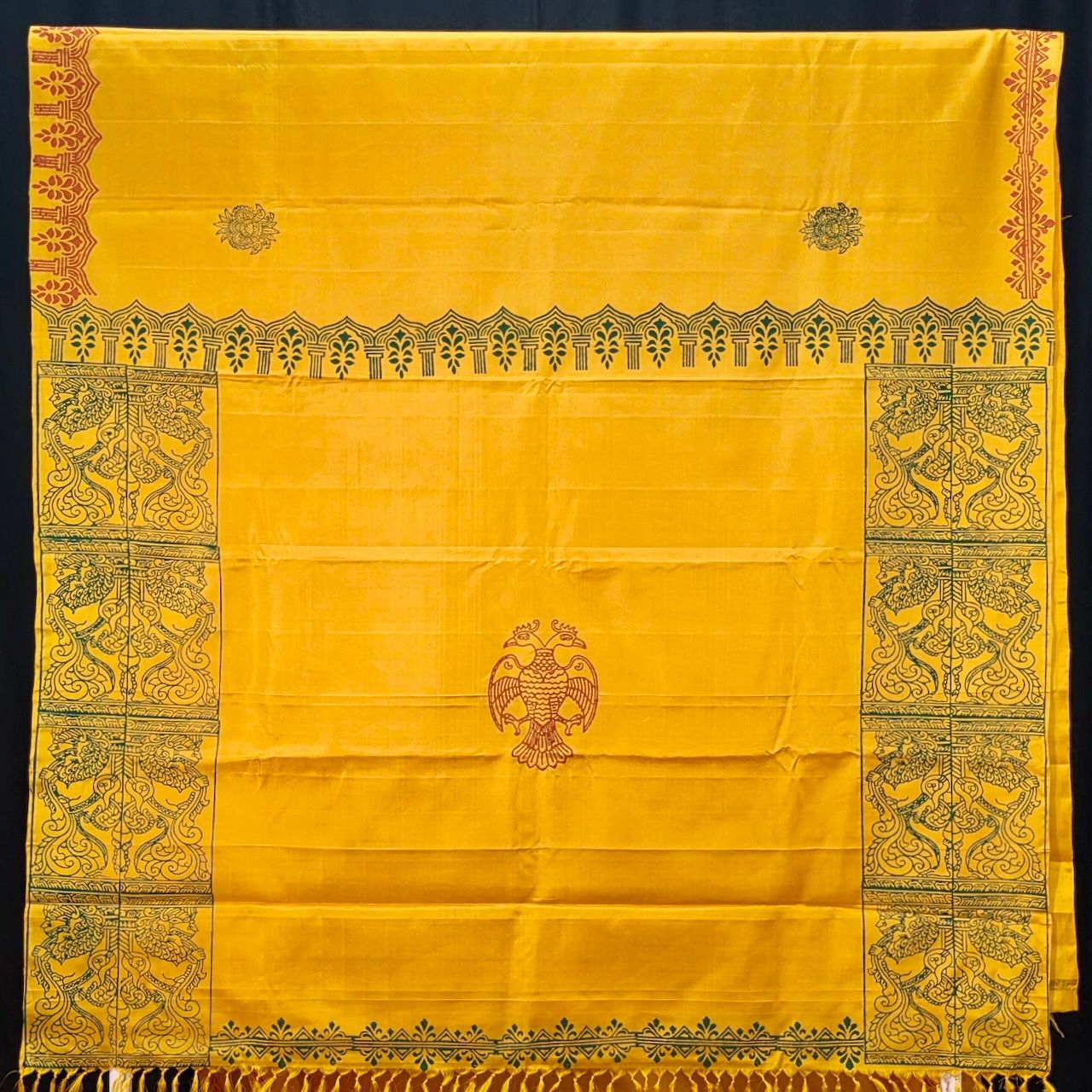 Block Printed Kanjivaram Silk Saree 001 — beautiful dark yellow 2 warp Kanjivaram silk saree block printed with Gandabherunda motif with Temple Pillar for Pallu, Saree body is printed with temple border prints with small Gandabhedunda motif. Saree comes with same color blouse that has same border prints in green color.