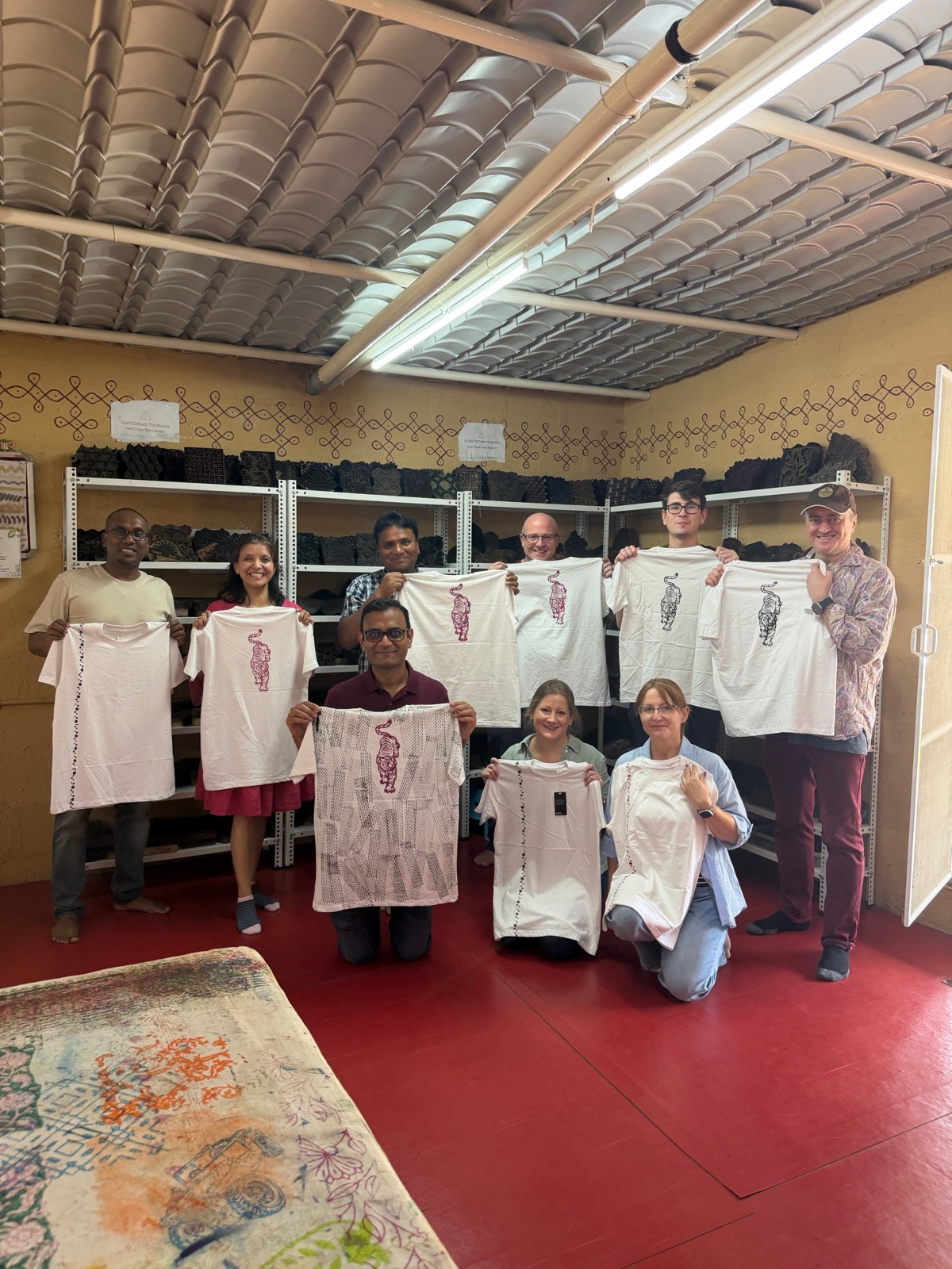 A corporate team holding up their printed T-shirts and pieces in the studio